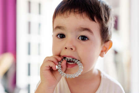 Cute little boy playing in room at home with various toysの写真素材