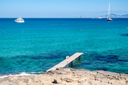Seascape with wooden walkway leading to turquoise sea and blue skyの写真素材