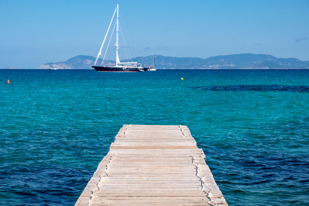 Seascape with wooden walkway leading to turquoise sea and blue skyの写真素材