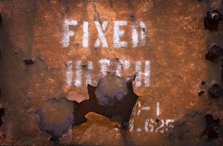 A peeling sign on a rusted metal surfaceの写真素材
