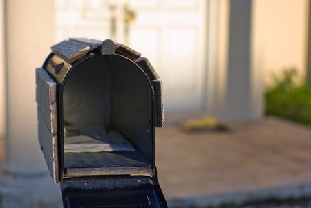 Open mailbox in front of abandoned house.の写真素材