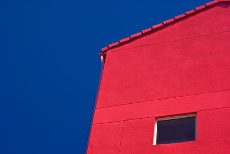 Red Building With One Window Against Cloudless Blue Skyの写真素材