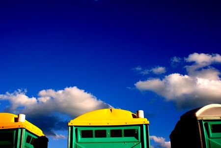Portable toilets lined up against deep-blue sky.の写真素材