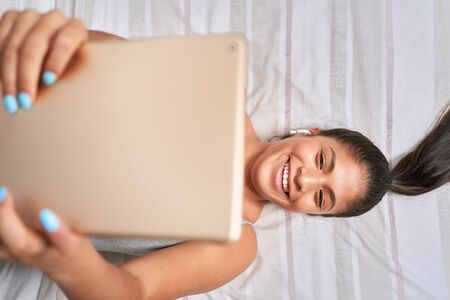 Female student doing online class and homework with her computer at home for coronavirus causes.