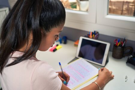 Female student doing online class and homework with her computer at home for coronavirus causes.の写真素材