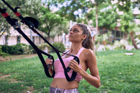 Fitness woman doing exercises on mat outdoorsの写真素材