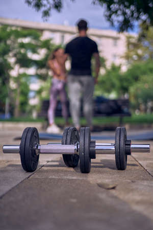 Fitness woman with personal trainer doing exercises on mat outdoorsの写真素材