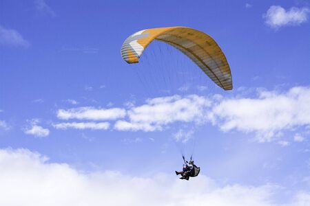 paragliding in the sky. People practicing paragliding and flying through the sky on vacationsの写真素材