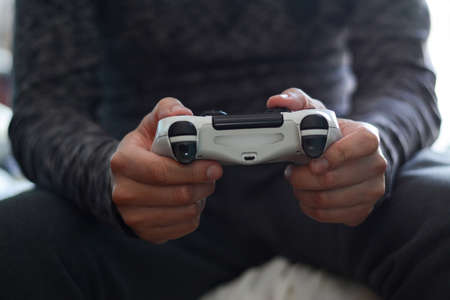 A man holding a game controller. A young man playing video games,の写真素材