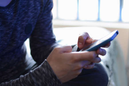 Closeup shot of a man typing on a smartphone