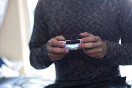 A man holding a game controller. A young man playing video games,