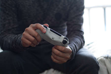 A man holding a game controller. A young man playing video games,の写真素材