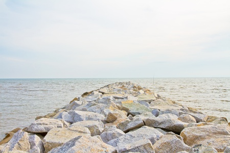 Seaside stone embankment with blue skyの写真素材