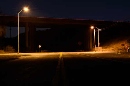 A night view of an intersection, near a bridge の写真素材