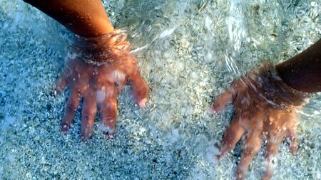 photos of my hands in the sea water this summerの写真素材