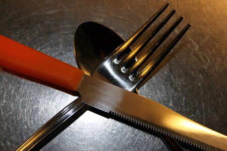 cross cutlery ready to be used for dinner, spoon fork and knifeの写真素材
