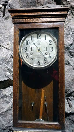 Kiruna, Sweden, February 22, 2020. An ancient grandfather clock resting on a wallのeditorial素材