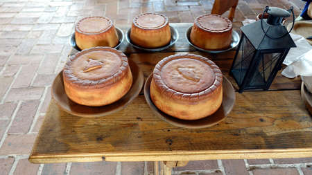 Five flans with meat or fish filling and an oil lantern on a wooden tableの写真素材