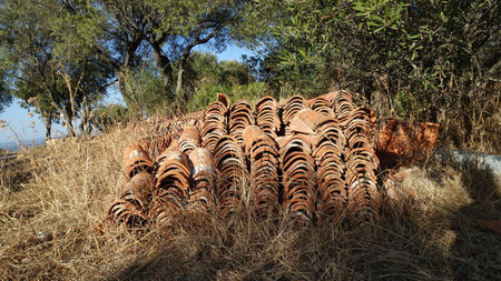 Hundreds of antique roof tiles piled in a row ready to be used for a new home.の写真素材