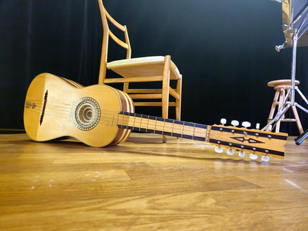 A handcrafted chitarra battente, a traditional Italian instrument, rests on the stage floor.