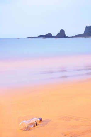Liquor bottle on the beach at sunriseの写真素材