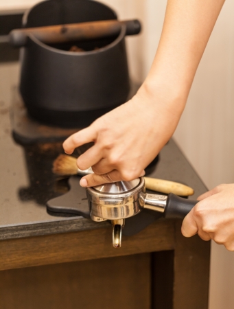 Barista prepares espresso in his coffeeshop; close-upの写真素材