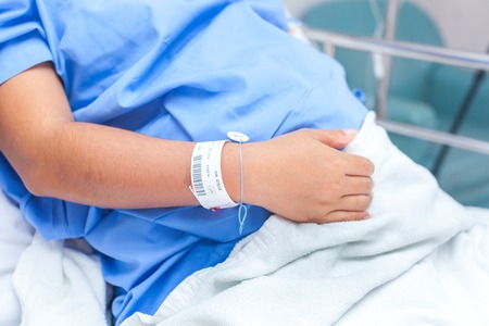 sick lady lying in hospital bedの写真素材