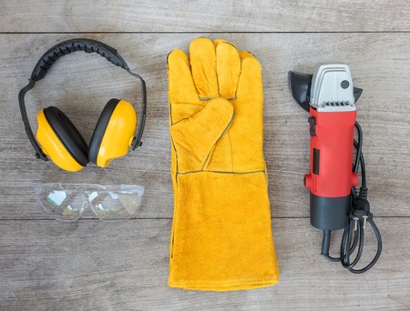 set of tools on wooden board, ear muffs,angle grinder,leather glovesの写真素材