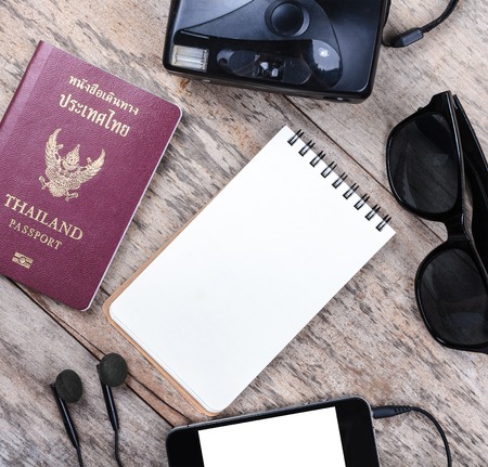 Preparation for travel,outfit, tablet ,passport, camera on wooden tableの写真素材