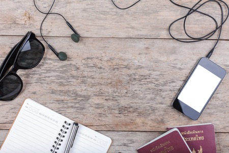 Preparation for travel,outfit, tablet ,passport, camera on wooden tableの写真素材