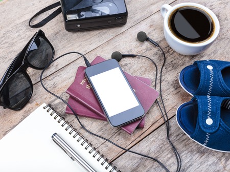 Preparation for travel,outfit, tablet ,passport, camera on wooden tableの写真素材
