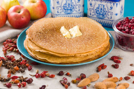 golden pancakes on a blue plate. Traditional feast on Russian Shrovetide.