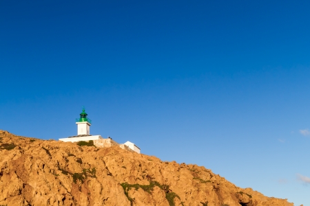 The lighthouse at Ile Rousse in the Balagne region of Corsica against a deep blue skyの写真素材
