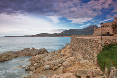 The coastline, rocks and fortress at Algajola in the Balagne region of Corsicaの写真素材