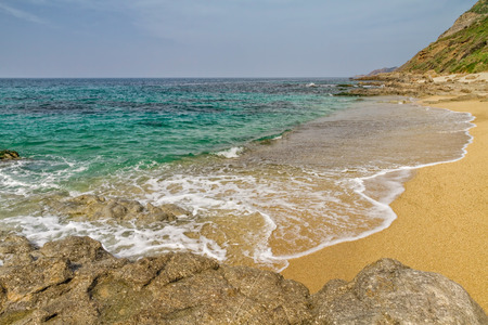 Sand and rocks on Losari beach in the Balagne region of Corsicaの写真素材