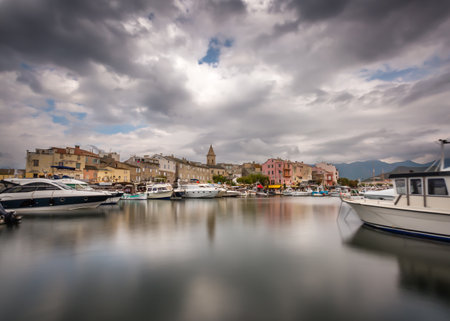 Dark clouds over the boats and harbour of Saint Florent in northern Corsicaのeditorial素材