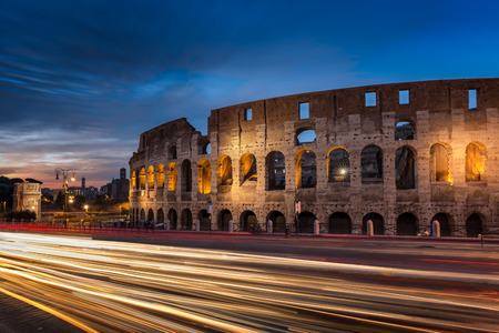 Light trails on the road at the Roman Colosseum amphitheatre in the city of Rome at duskの写真素材