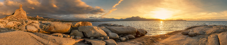 Panoramic view at sunset of the Genoese tower and rocky coastline at Punta Caldanu looking over...