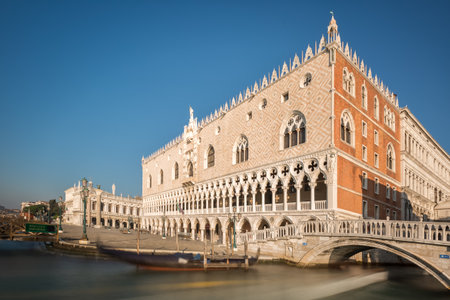A slow shutter image of boats passing under a bridge by the Doge's palace or Palazzo Ducale near Piazza San Marco in Veniceのeditorial素材