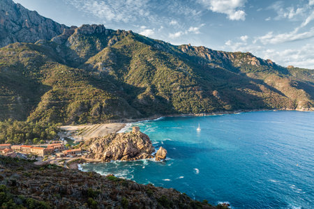 Genoese tower on a rocky headland jutting out into the turquoise mediterranean sea at Porto on the west coast of Corsicaのeditorial素材