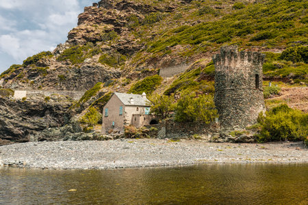 Ancient stone Genoese tower and small house standing on the coast at the mouth of the RiviÃ¨re...