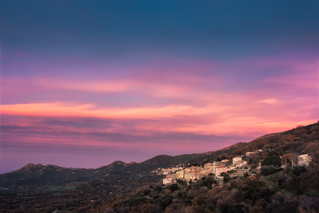 Dramatic pink and orange sunset over the mountain villages of Costa and Belgodere in the Balagne region of Corsicaの写真素材