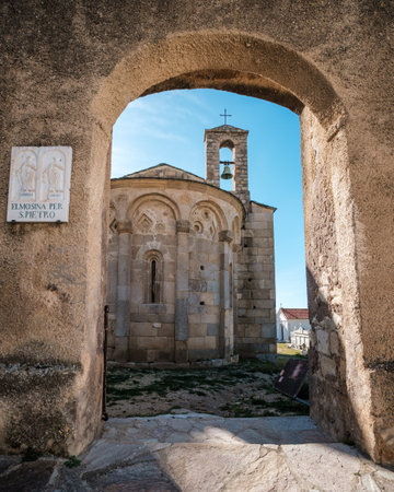 Stone archway entrance to 11th Century San Pietro and San Paolo Roman chapel and surrounding graveyard at Lumio in the Balagne region of Corsica.のeditorial素材