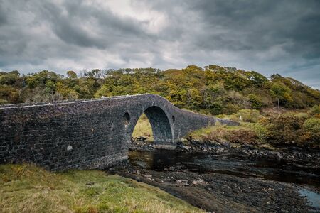Clachan Bridge, a stone, single arch bridge, built in 1793 and known as the Bridge over the Atlantic, spans Clachan Sound between mainland Scotland and Seil Islandの写真素材
