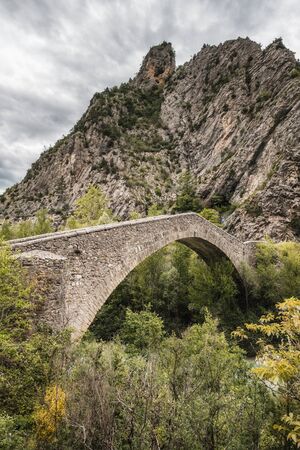 Pont de la Reine Jeanne is a narrow 16th century stone bridge over the Coulomp river near Saint-Benoit in the Alpes-de-Haute-Provence region of Franceの写真素材