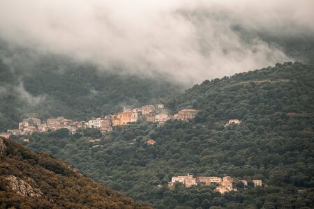 The ancient mountain villages of Muro and Poggiali in the Balagne region of Corsica under dark storm cloudsの写真素材