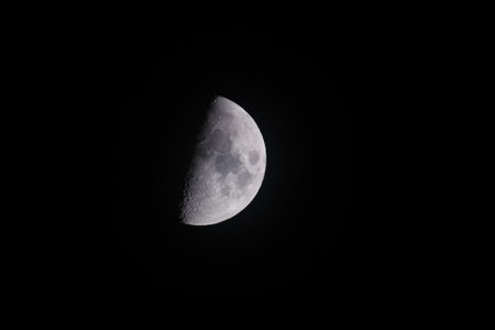 A half-moon against a dark black sky