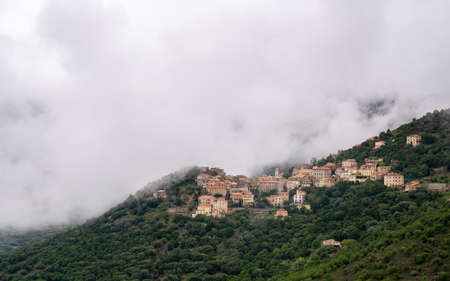 Mountain village of Belgodere surrounded by woodland in the Balagne region of Corsica under a...