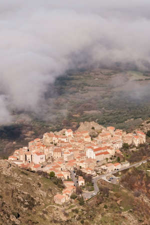 Cloud hangingover the ancient mountain village of Speloncato in the Balagne region of Corsicaの写真素材