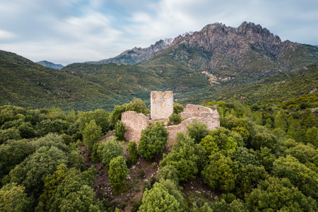 Aerial view of the ruins of Castellu di Seravalle in Corsica, a military fortress built in the 11th century on a hilltop with the village of Popolasca iwith les Aiguilles de Popolasca in the distanceのeditorial素材